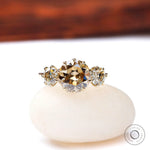 Front view champagne moissanite three stone ring on white base