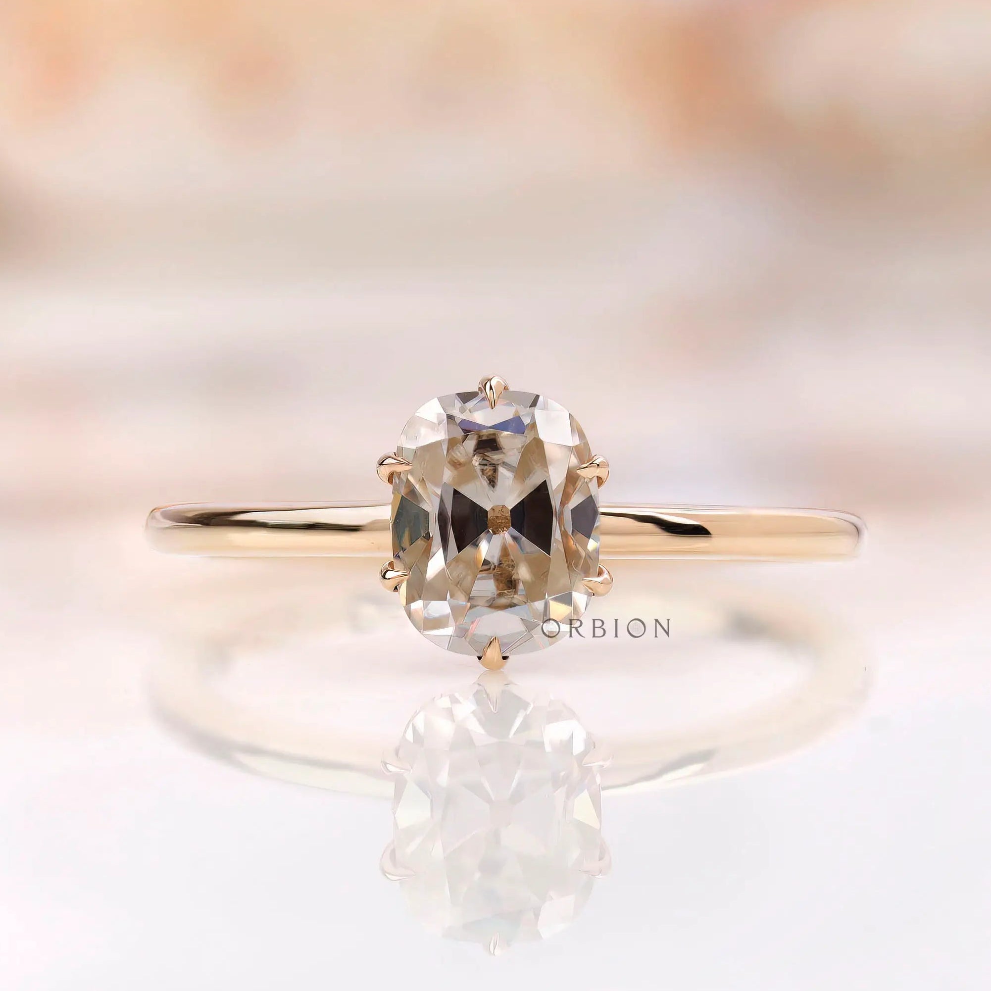 Front view of elongated cushion off white moissanite ring in yellow gold