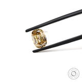 Champagne elongated cushion moissanite held between black tweezers
