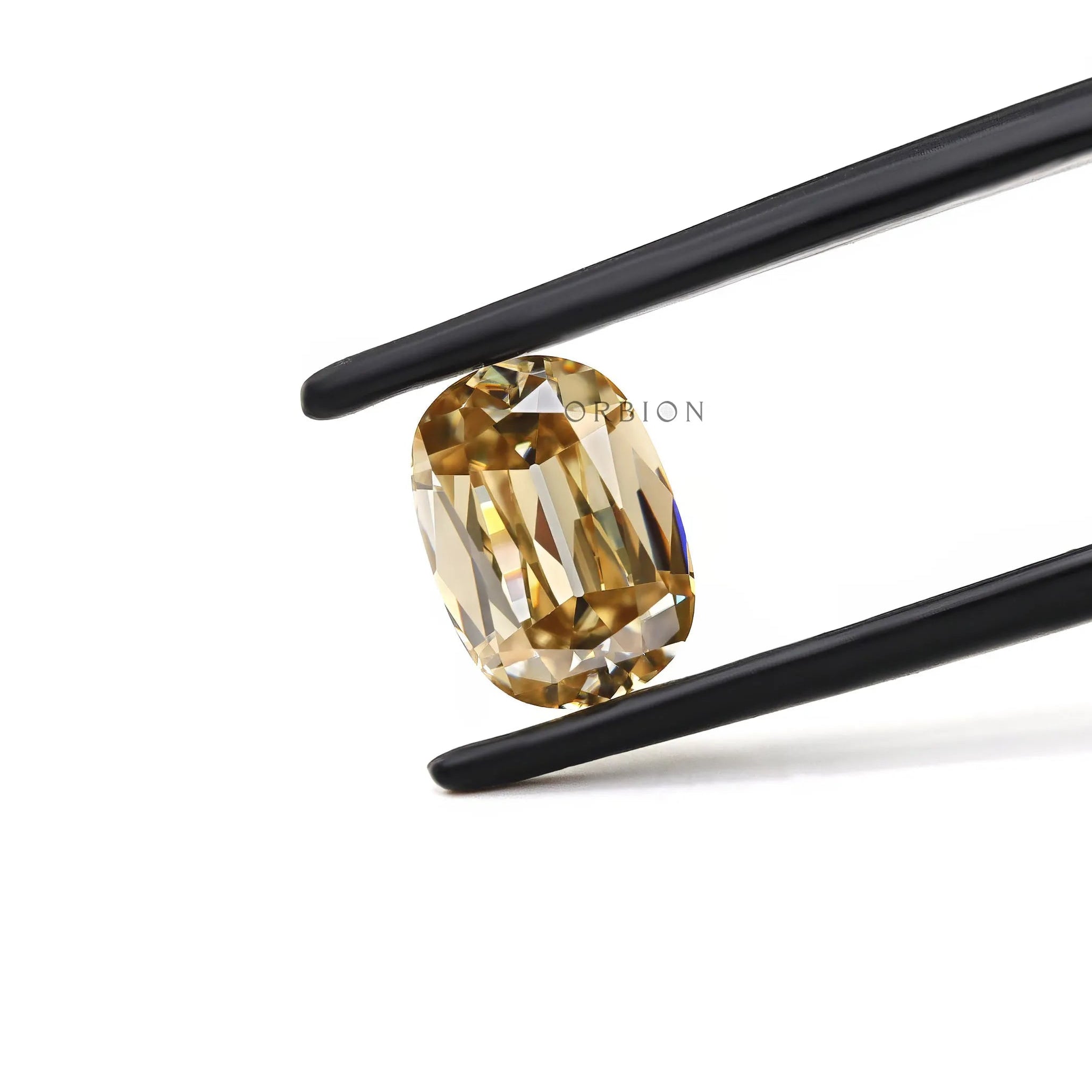 Champagne elongated cushion moissanite held between black tweezers