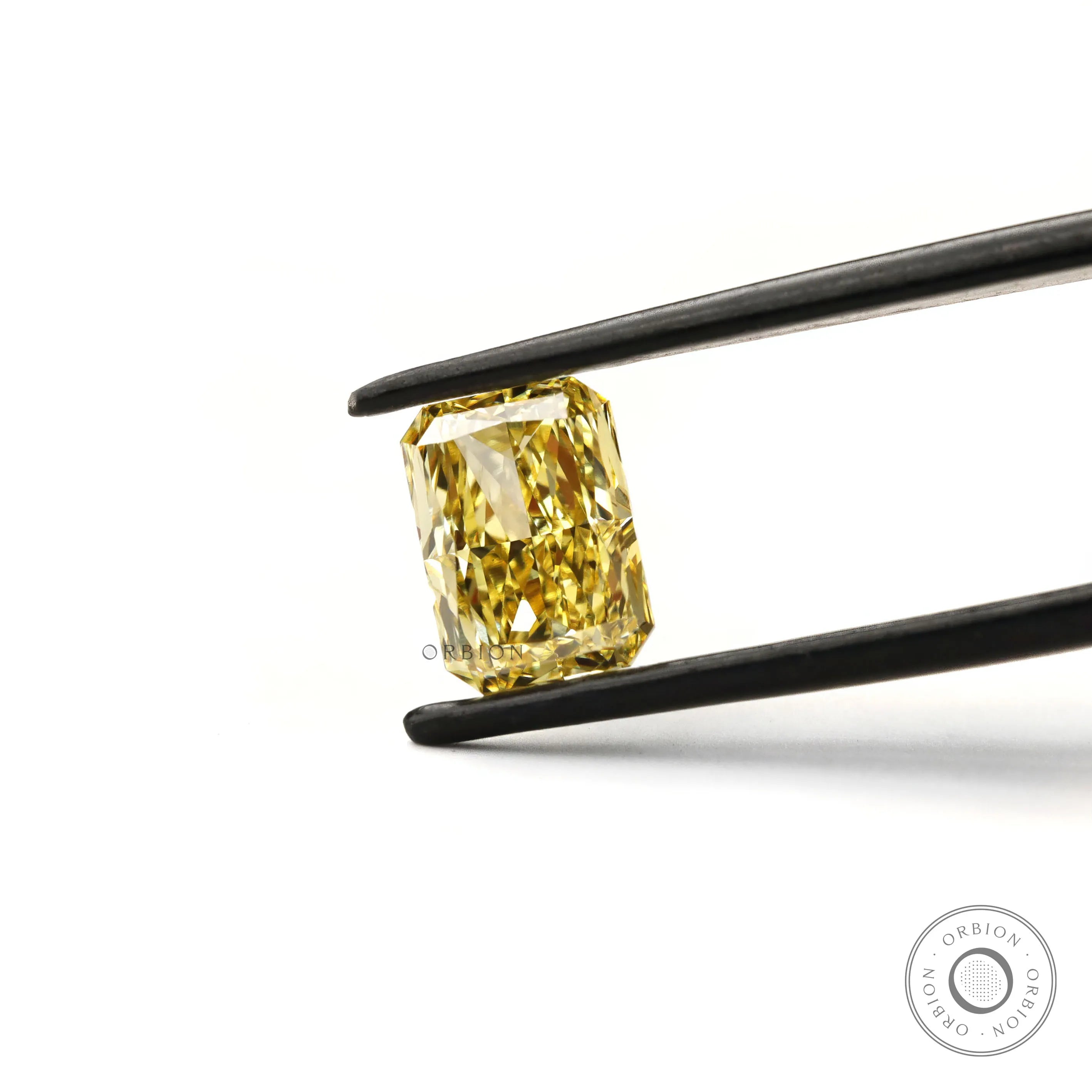 Fancy intense yellow radiant cut lab diamond in tweezers