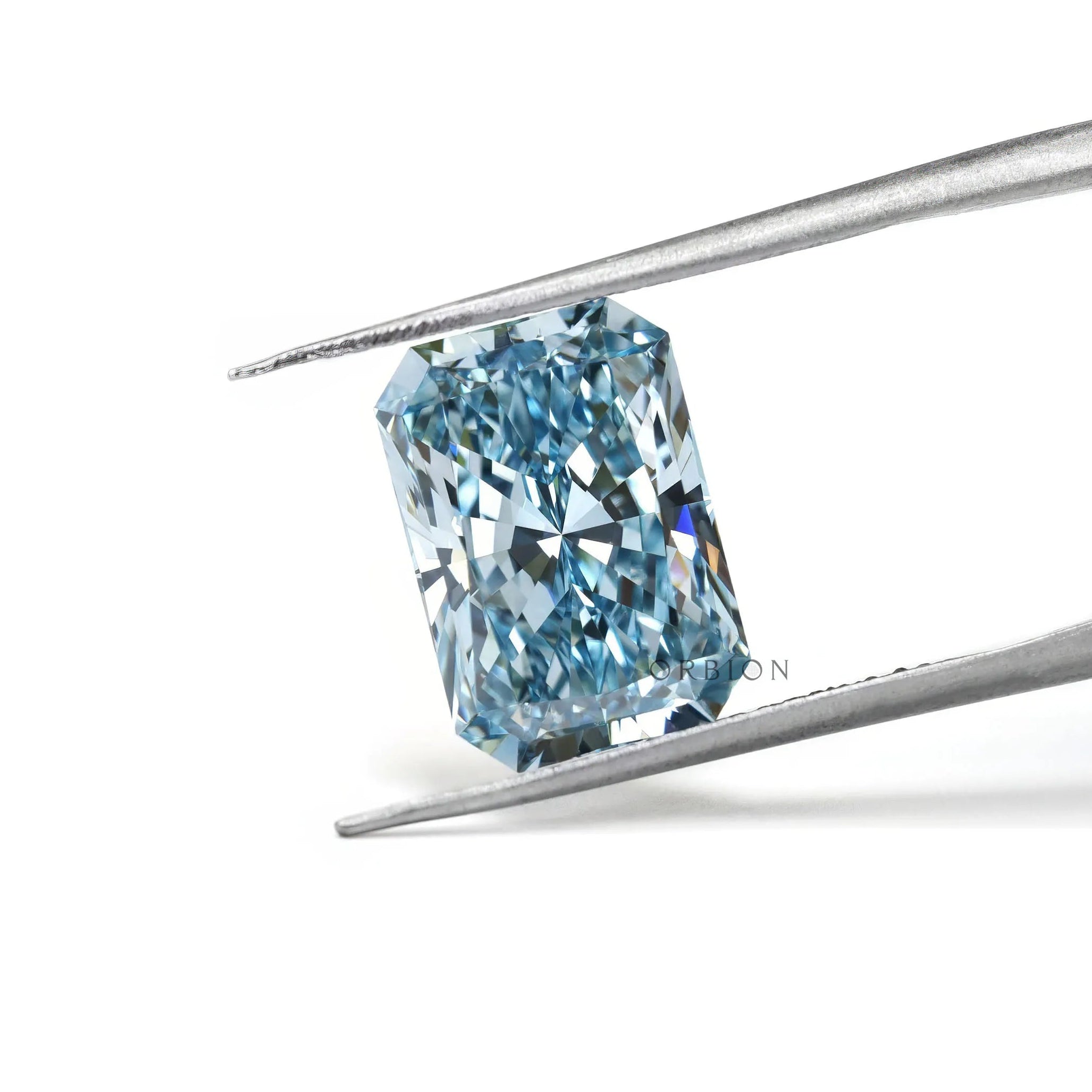 Fancy vivid blue radiant lab diamond held in silver tweezers