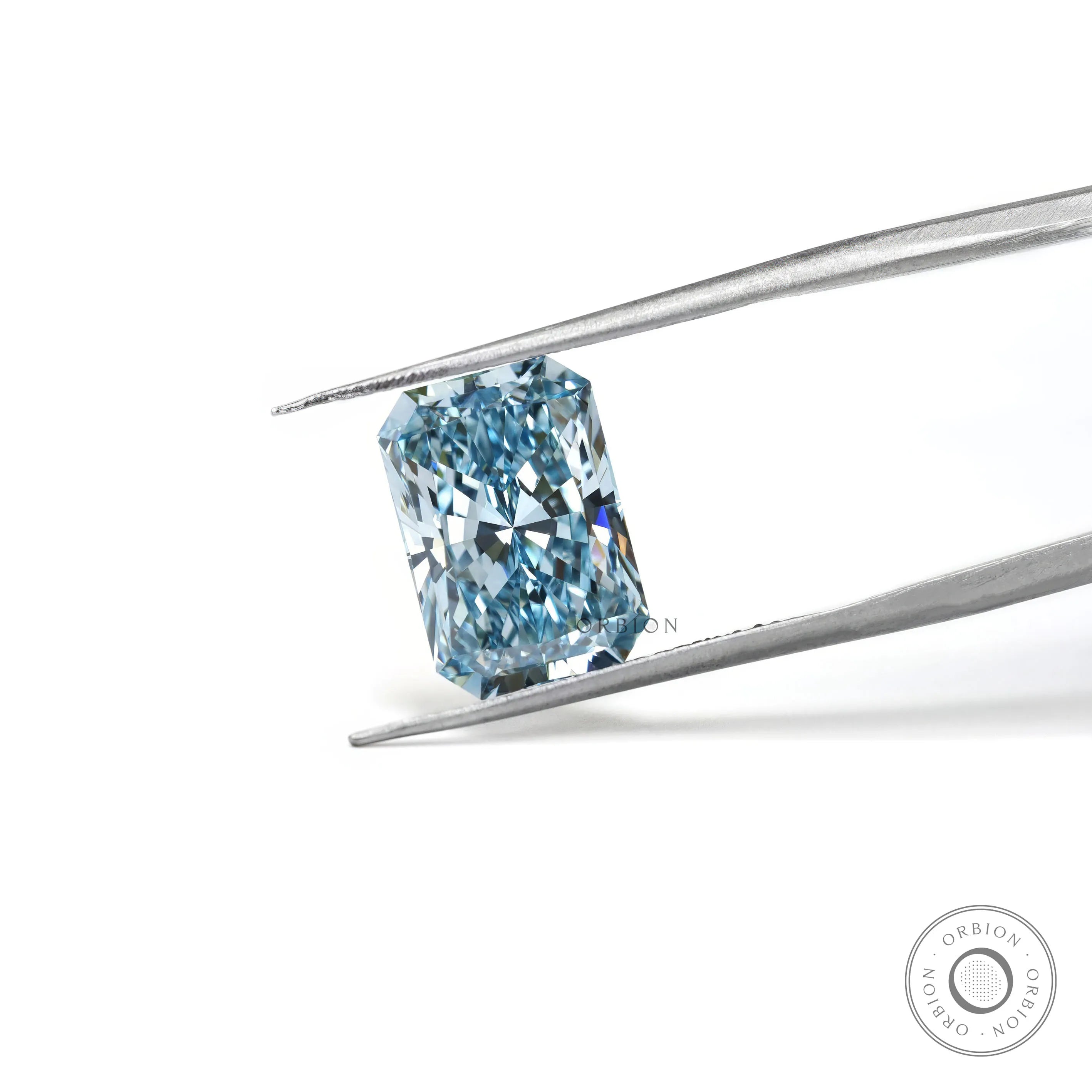 Fancy vivid blue radiant lab diamond held in silver tweezers