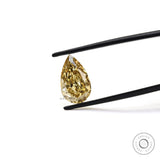 Fancy intense brownish yellow pear diamond held in tweezers