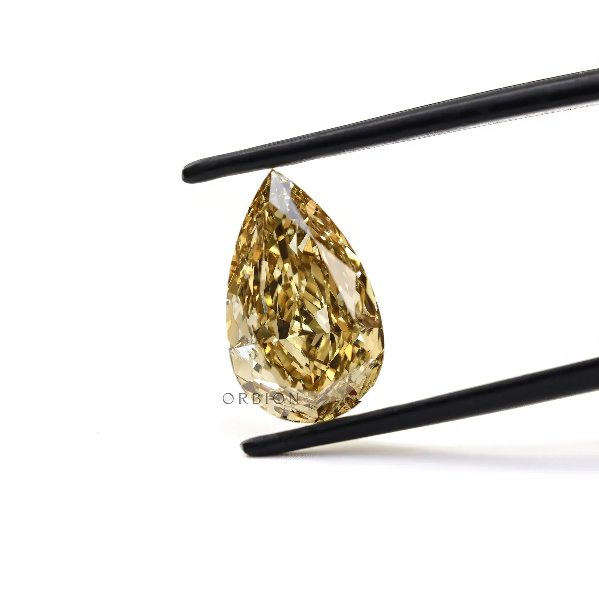 Fancy intense brownish yellow pear diamond held in tweezers
