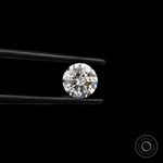 Round nova cut loose lab diamond held in black tweezers on black background