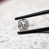 Elongated cushion old mine cut moissanite in tweezer close-up