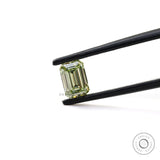 Fancy green emerald cut loose lab diamond in tweezers
