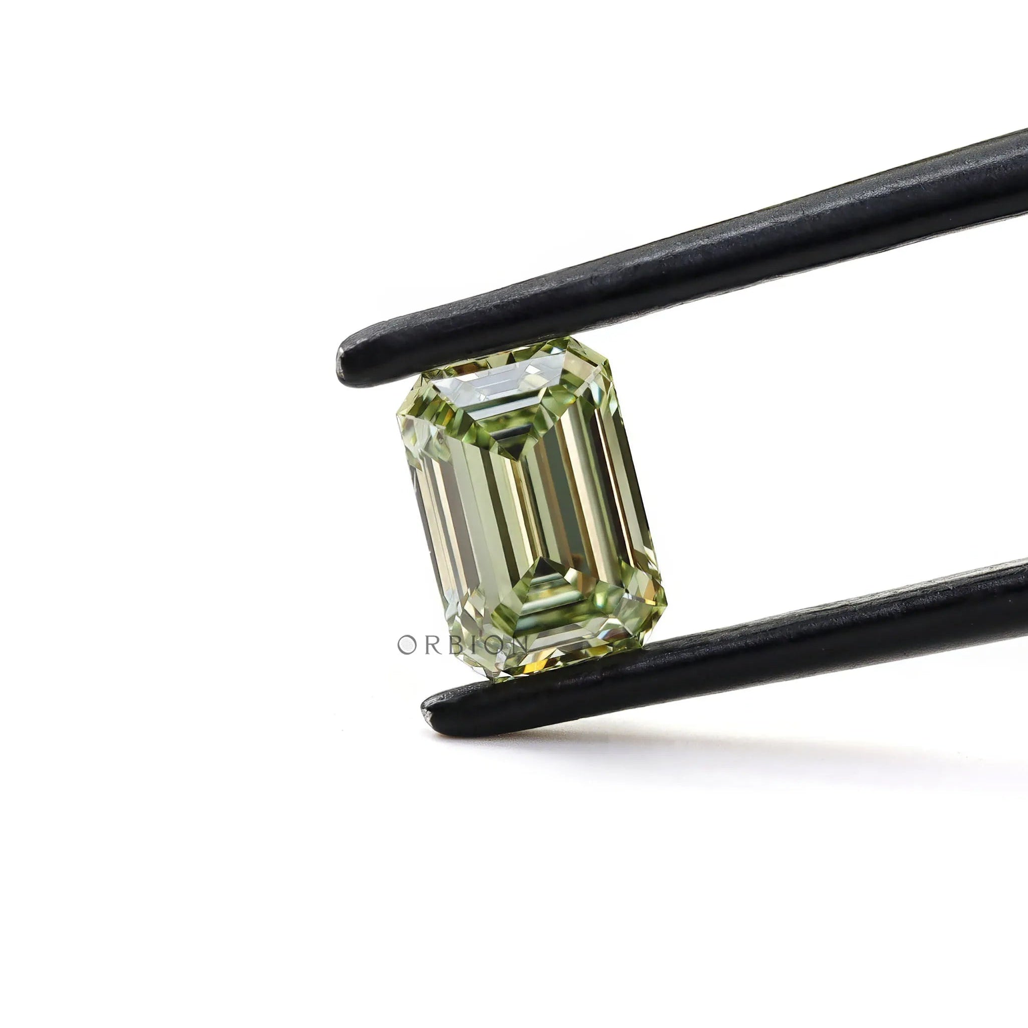Fancy green emerald cut loose lab diamond in tweezers