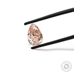 Fancy vivid pink pear lab diamond held in tweezers