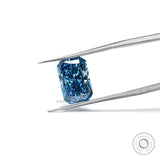 Fancy vivid blue radiant lab diamond held in silver tweezers