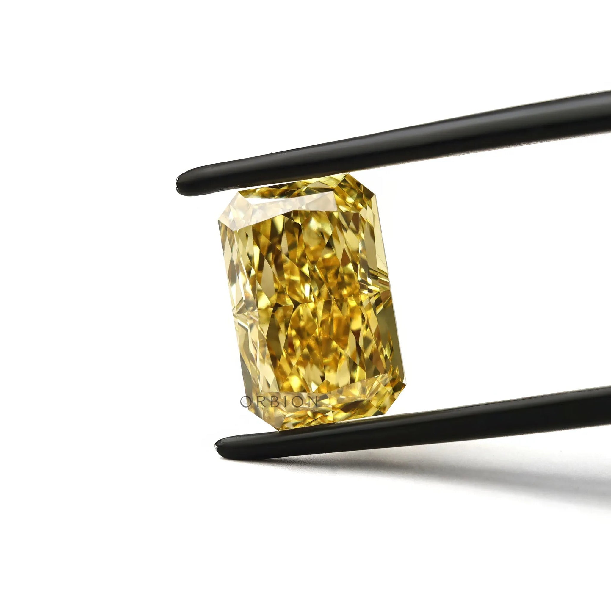 Fancy vivid yellow radiant cut lab diamond in tweezers