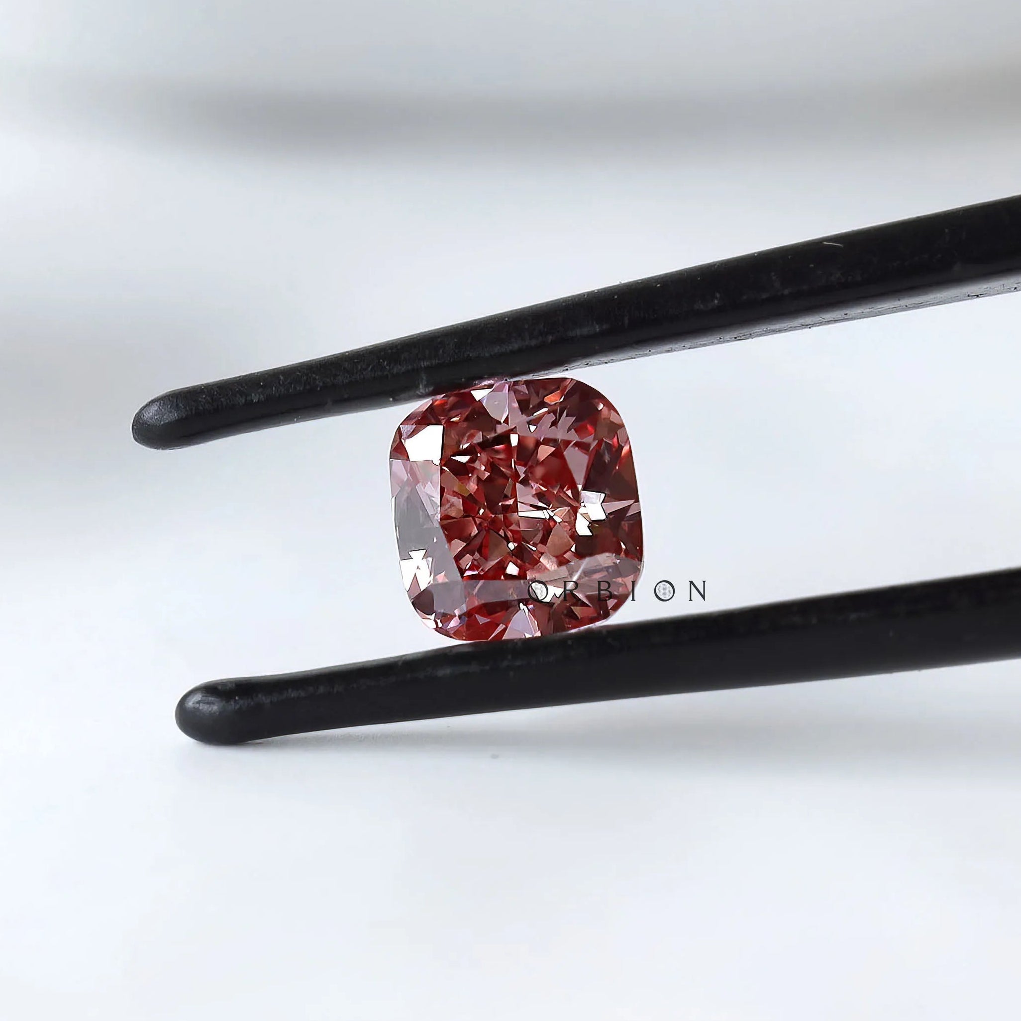 Fancy deep purplish pink cushion lab diamond in tweezers