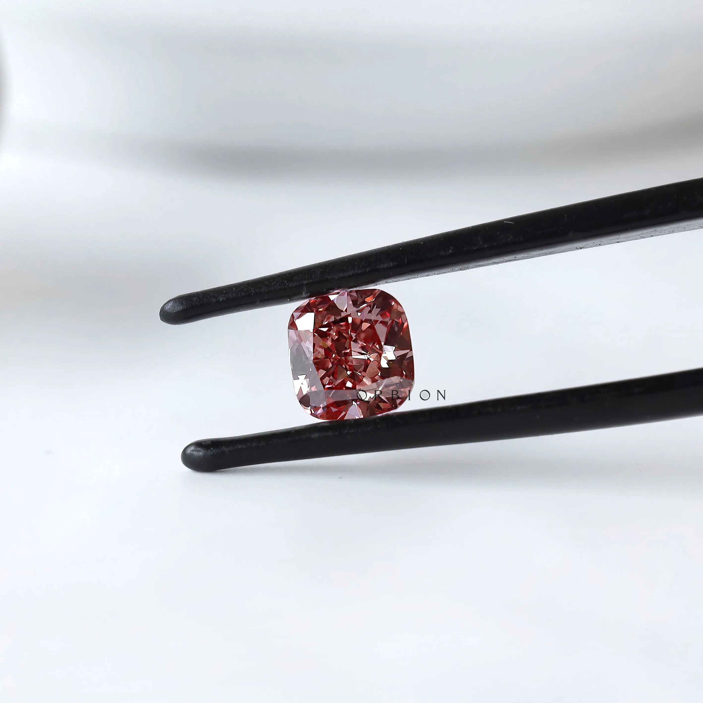 Fancy deep purplish pink cushion lab diamond in tweezers