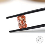 Fancy pink radiant cut lab diamond held in black tweezers