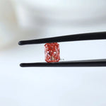Fancy vivid pink radiant diamond shown in tweezers