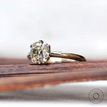 Angled view of off white moissanite engagement ring in two tone gold