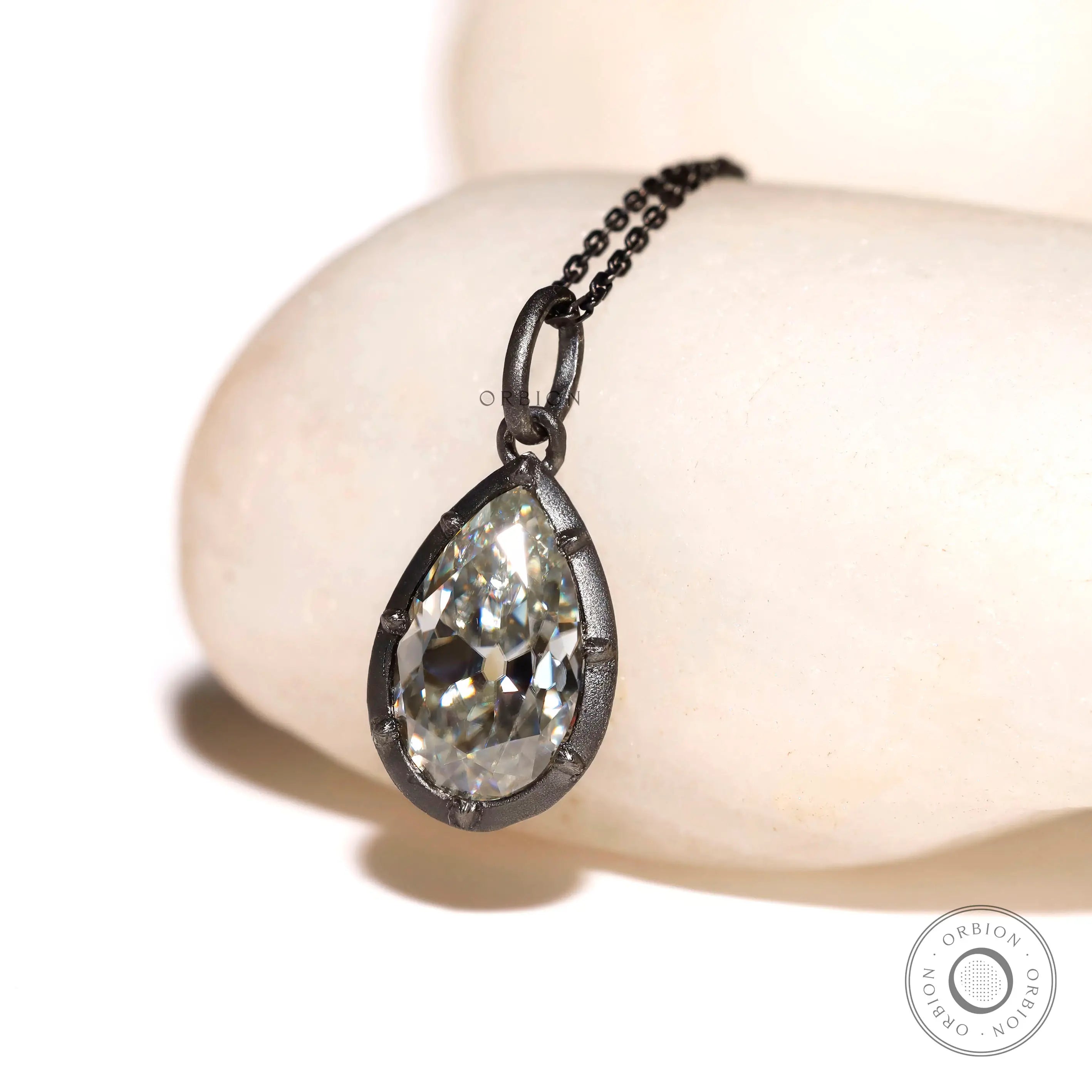 Angled view of old mine cut pear moissanite pendant