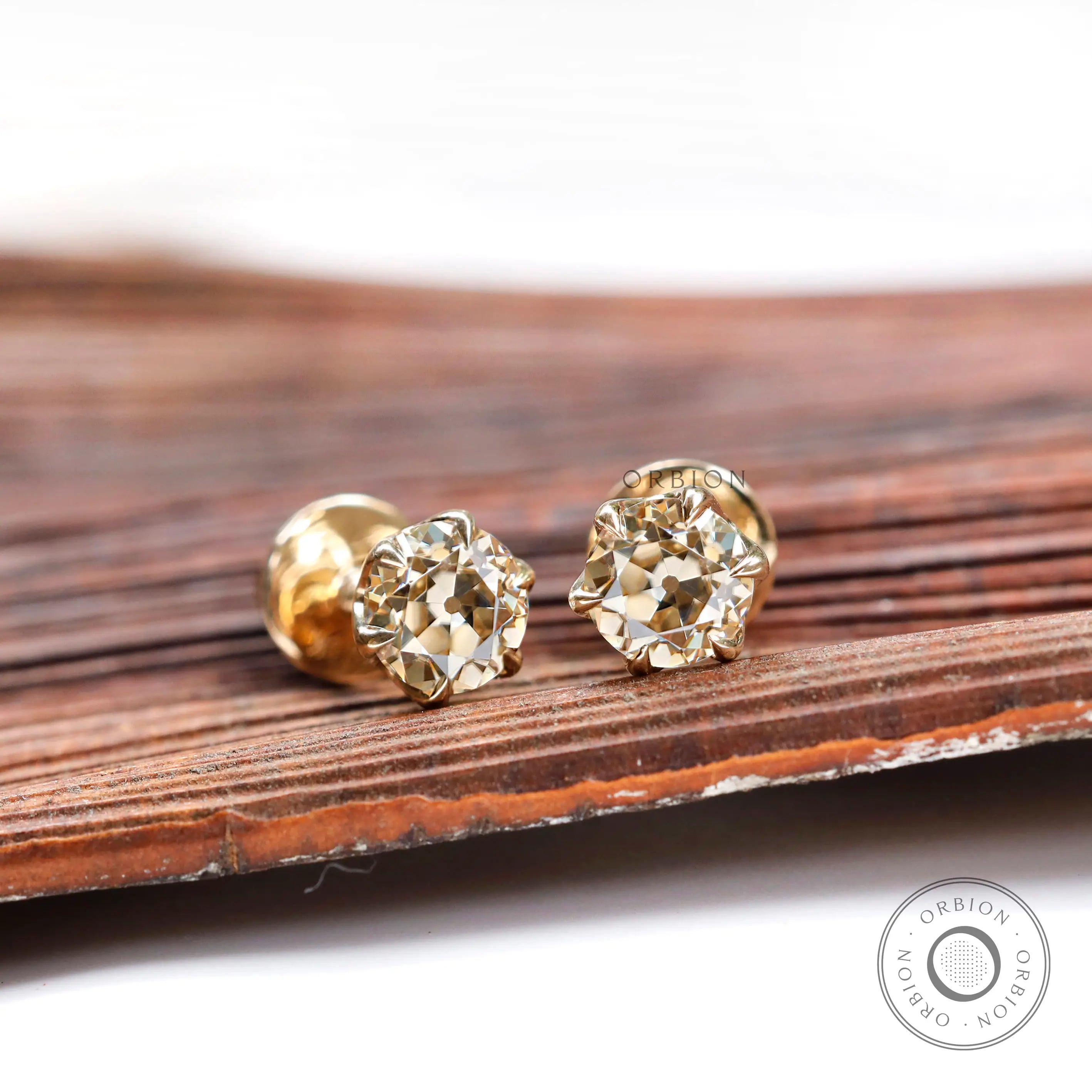 Angled view OEC champagne moissanite stud earrings yellow gold