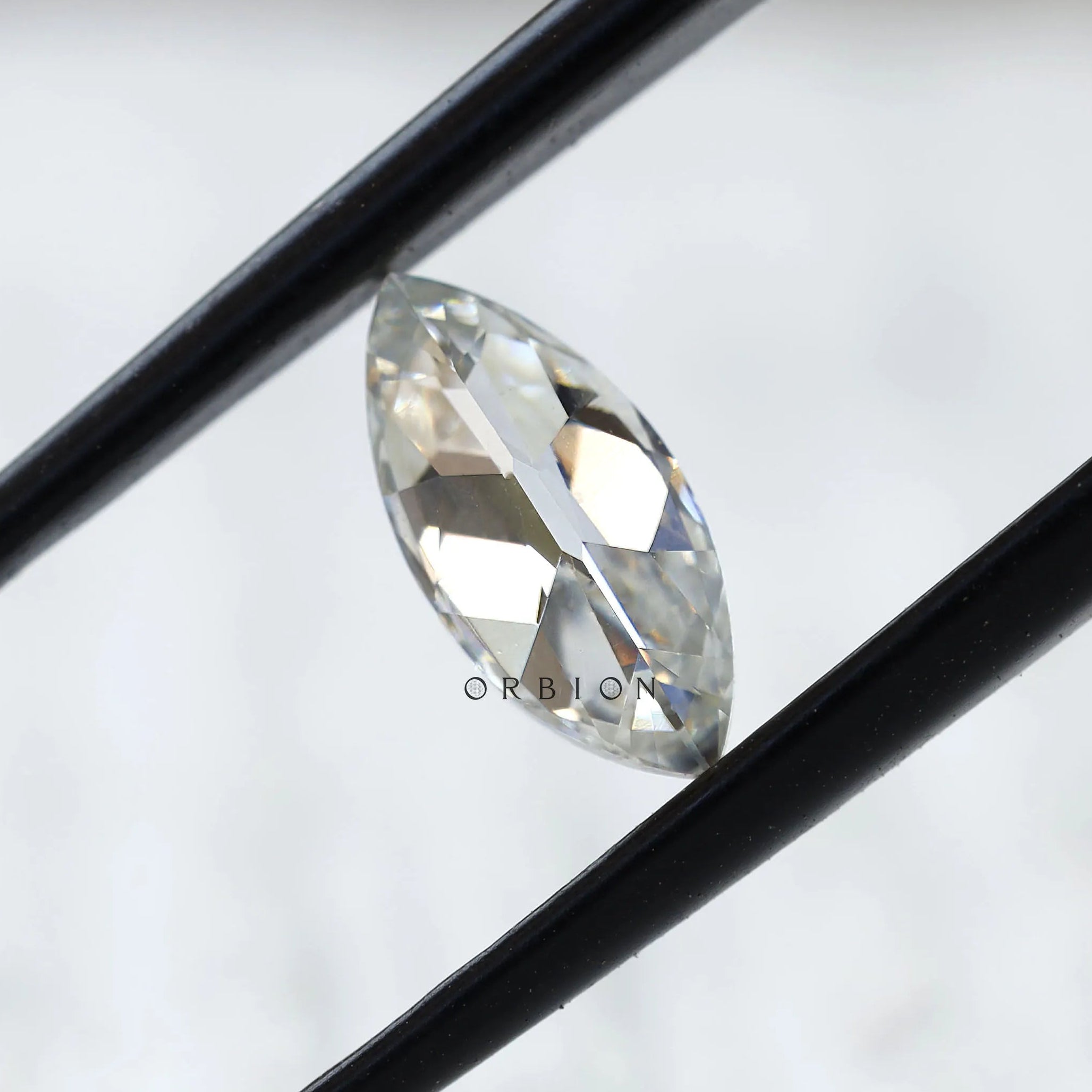 Close-up of marquise loose moissanite held in tweezers