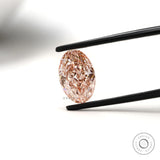 Intense pink oval lab grown diamond held in black tweezers