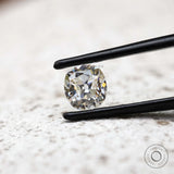 DEF elongated cushion loose moissanite shown in black tweezers