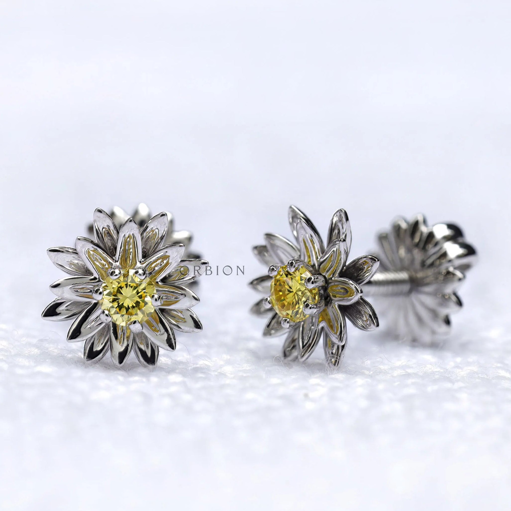 Side view of lotus flower stud earrings with yellow diamond.