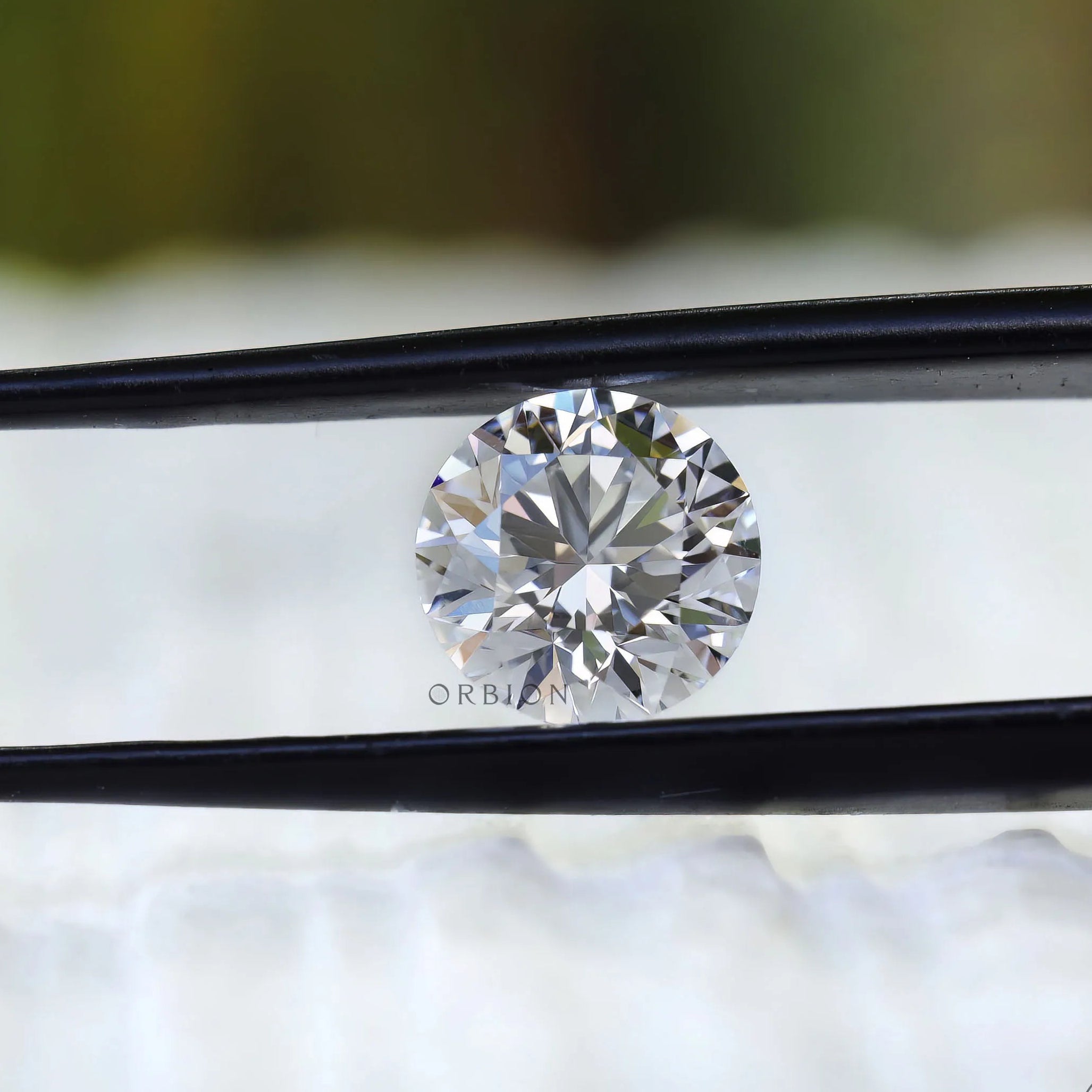 Colorless round lab diamond close up on white surface