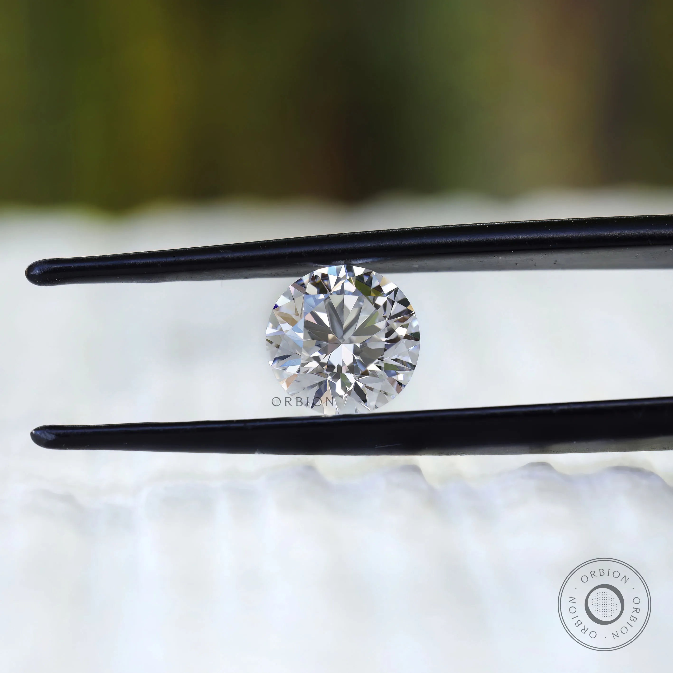 Colorless round lab diamond close up on white surface