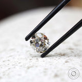 GHI elongated cushion moissanite held in black tweezers close-up