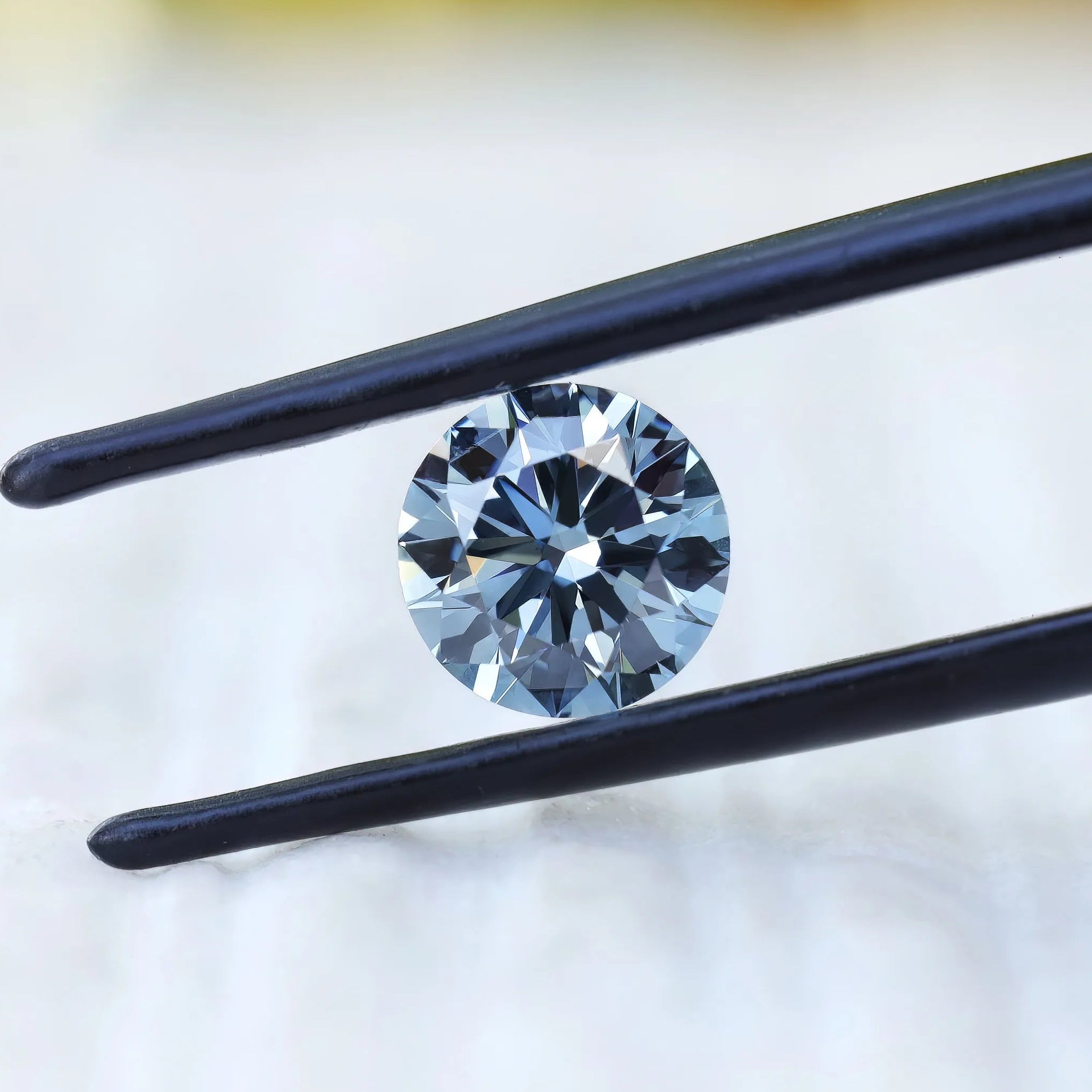 Angled close view of round blue brilliant lab diamond