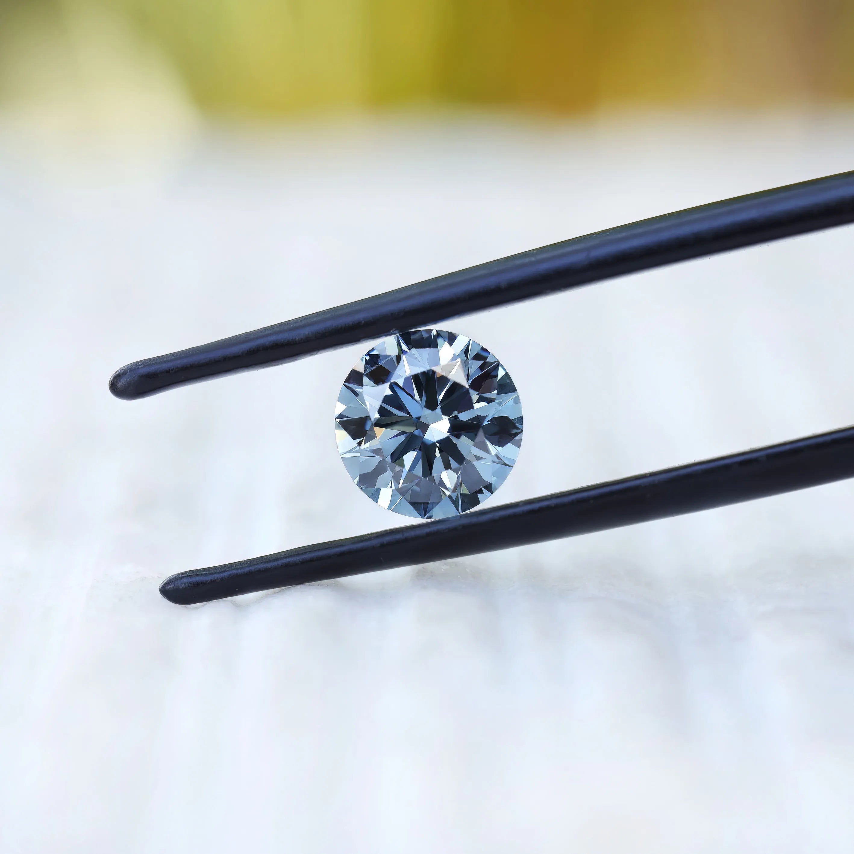 Angled close view of round blue brilliant lab diamond