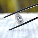Angled pear old mine cut moissanite in black tweezers