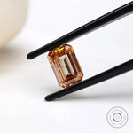 Angled view of orange emerald cut loose lab diamond