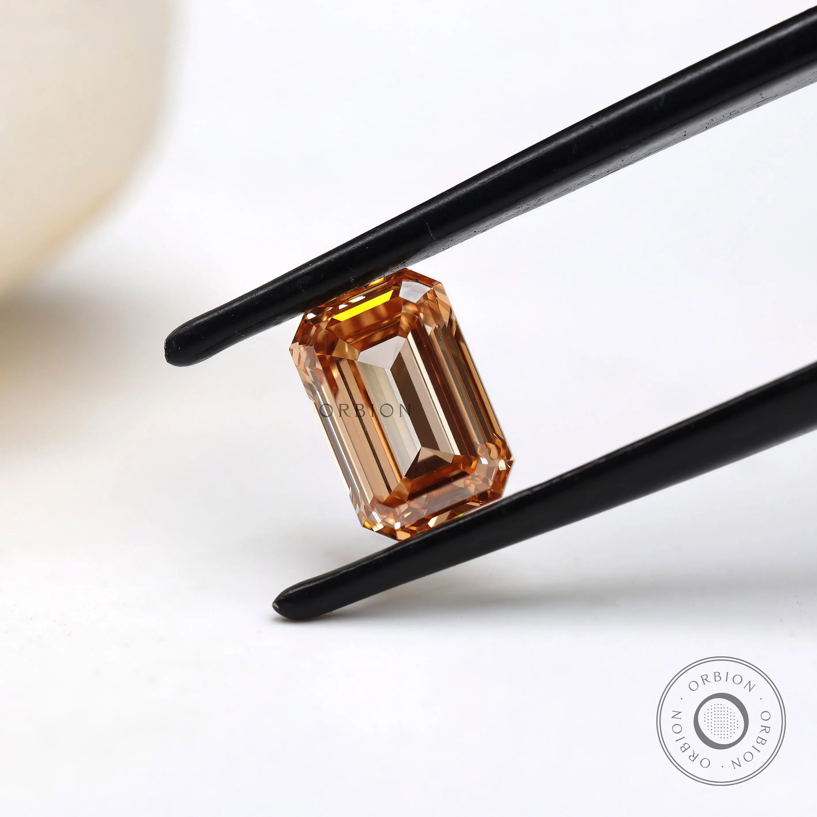 Angled view of orange emerald cut loose lab diamond