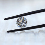 DEF round moissanite showing antique faceting in tweezers