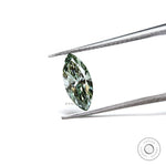 Loose green marquise brilliant cut diamond angled in tweezers