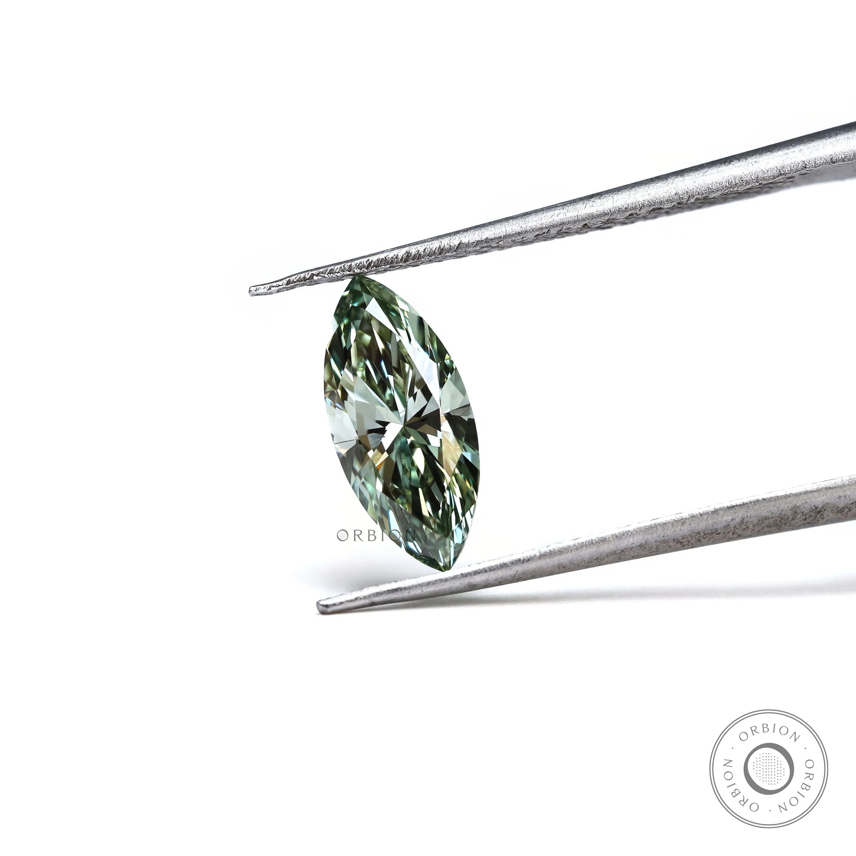 Loose green marquise brilliant cut diamond angled in tweezers