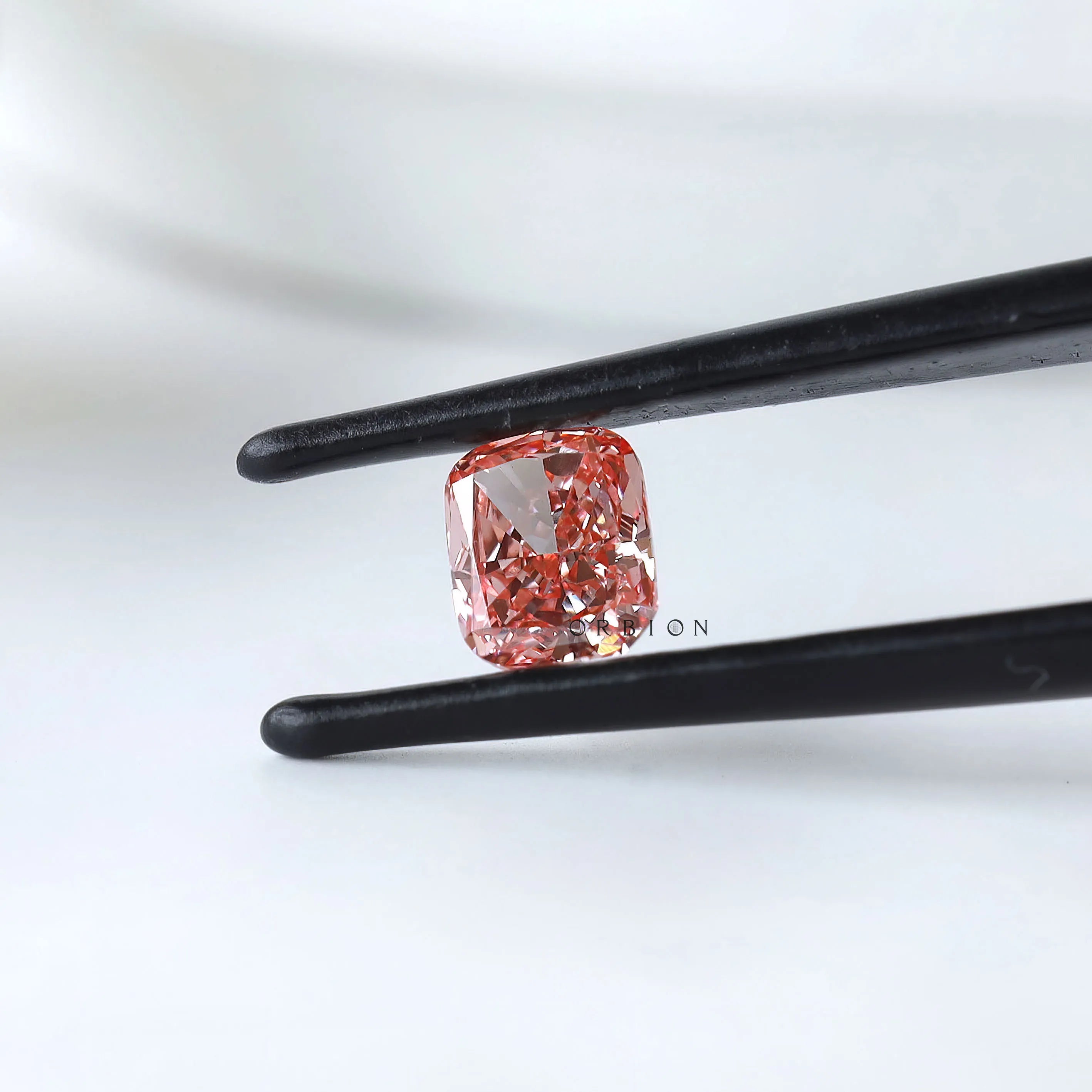 Cushion modified brilliant vivid pink lab diamond angled in tweezers