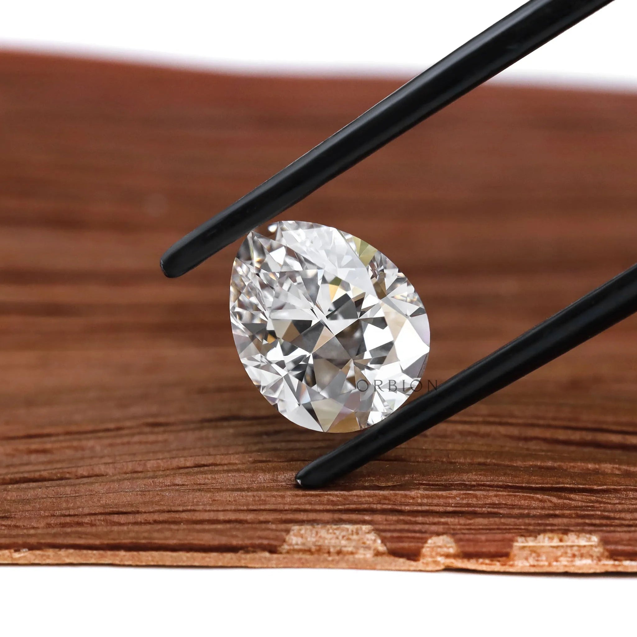 Loose pear lab diamond in tweezers with bright sparkle