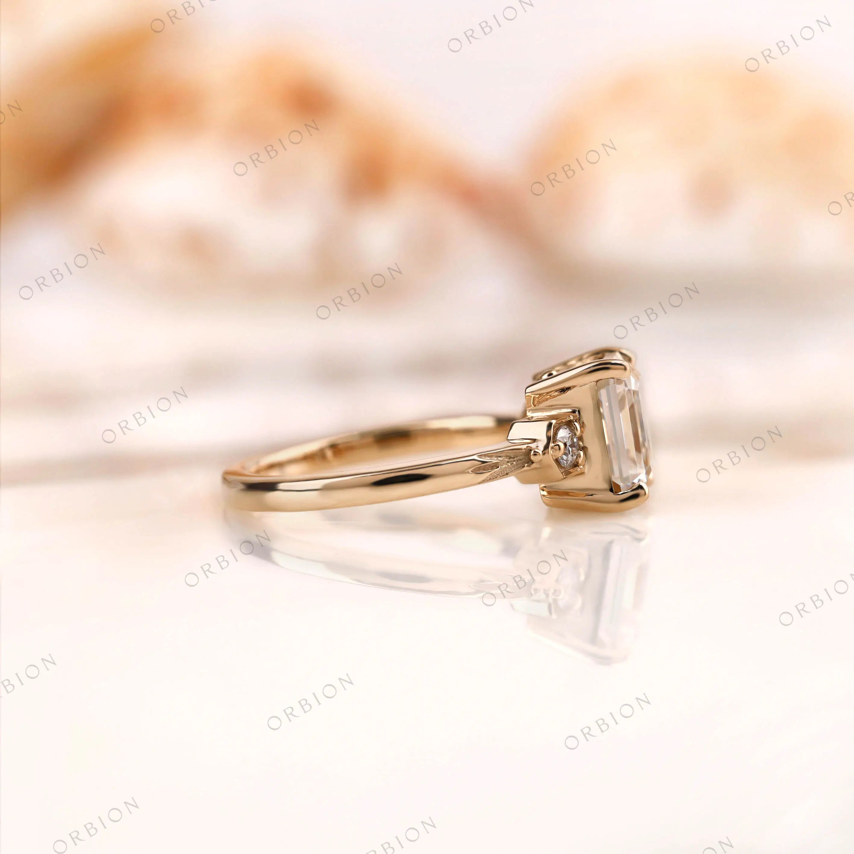 Side view of three stone asscher moissanite ring with floral engraving