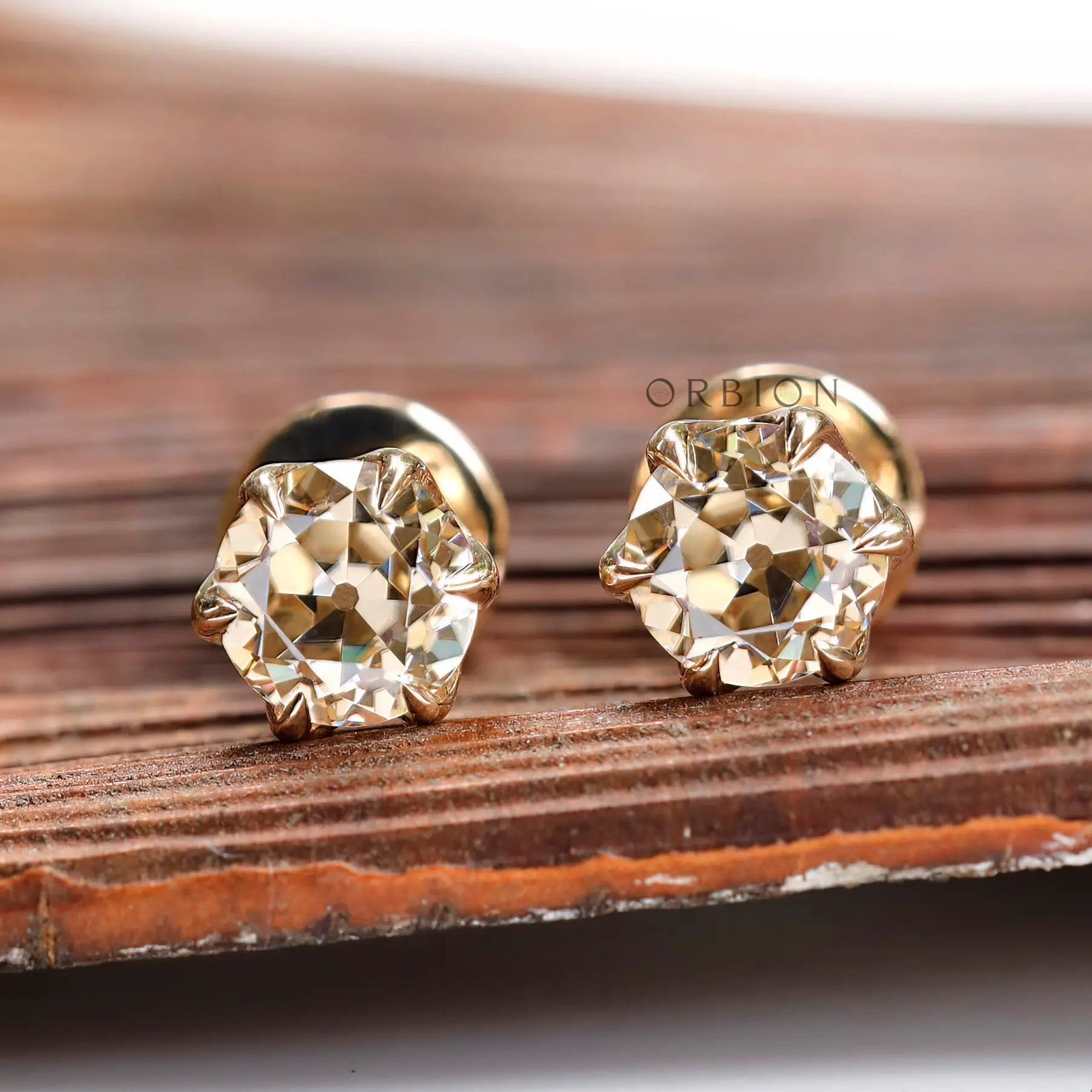 Front view light champagne moissanite stud earrings yellow gold