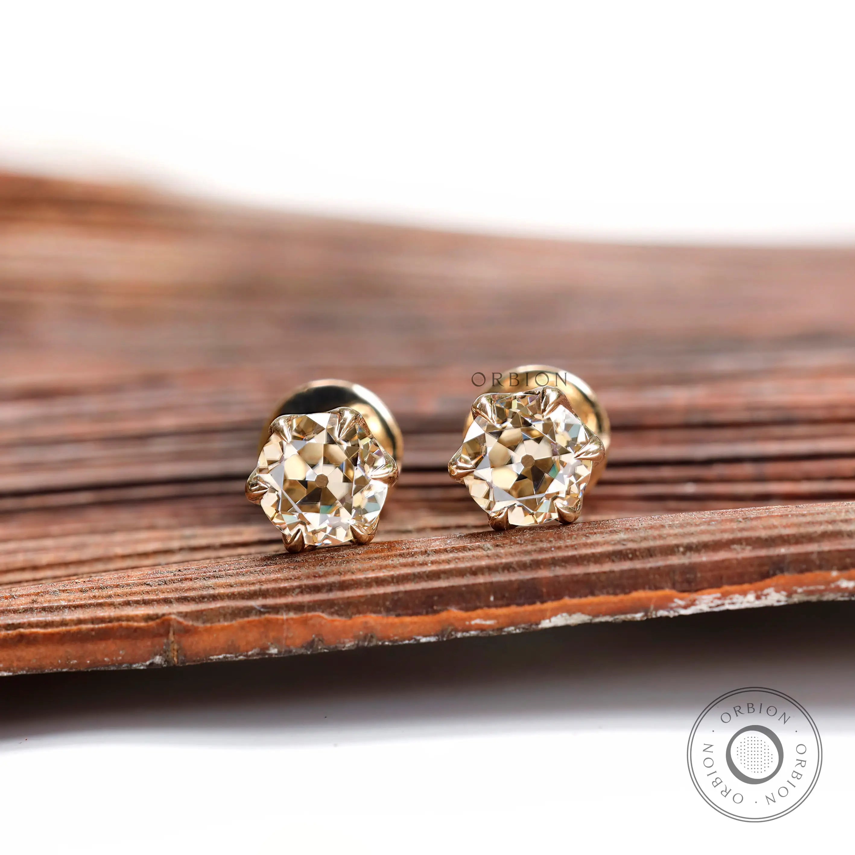 Front view light champagne moissanite stud earrings yellow gold