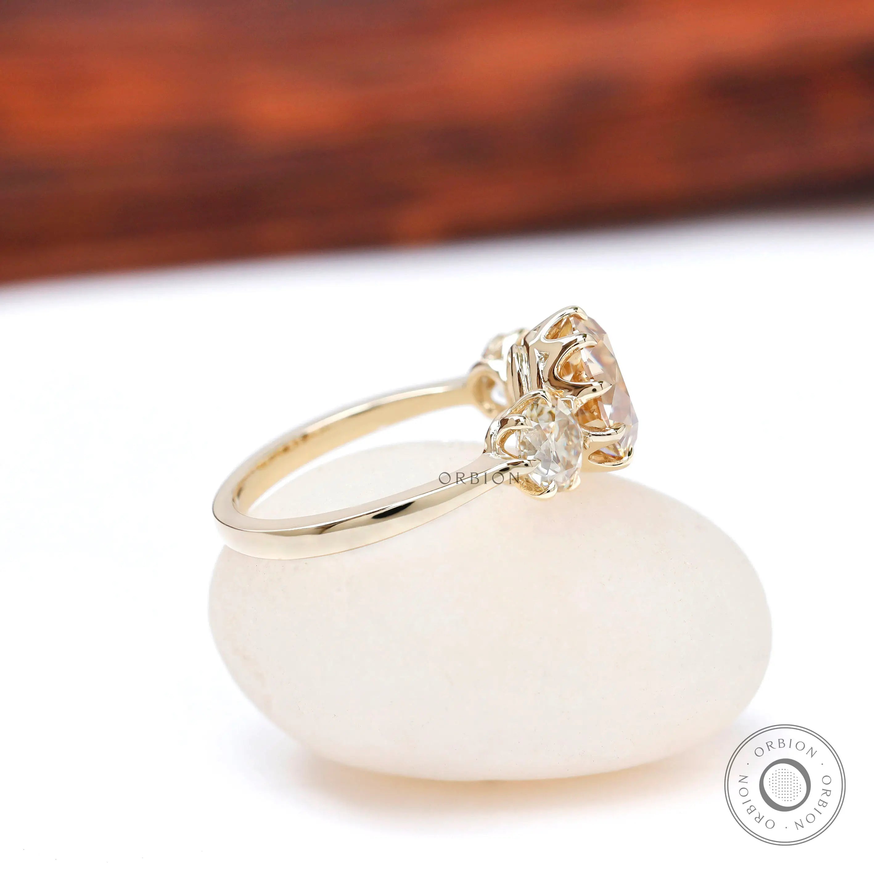 Side profile champagne moissanite three stone ring yellow gold