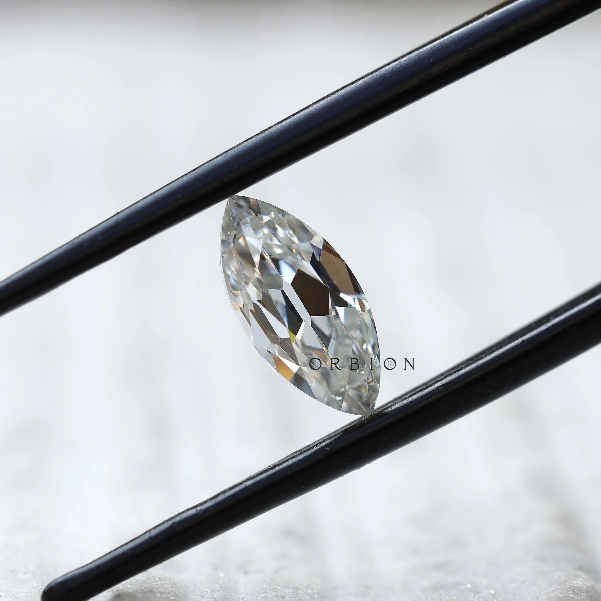 1.26 ct marquise cut moissanite in black tweezers