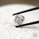 Angled cushion brilliant cut moissanite on light stone background