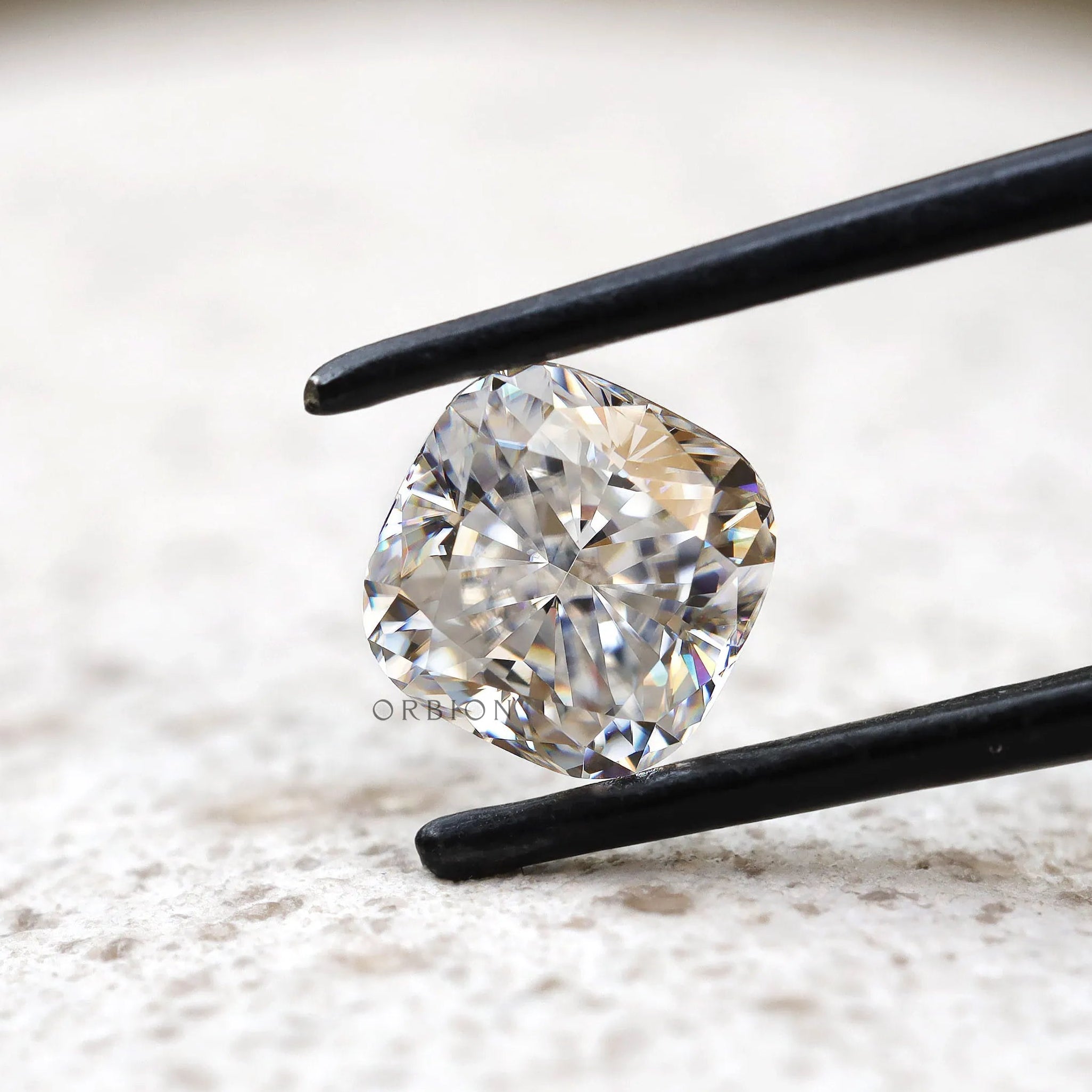 Angled cushion brilliant cut moissanite on light stone background