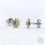 Close-up of lotus flower stud earrings with yellow diamond centerpiece