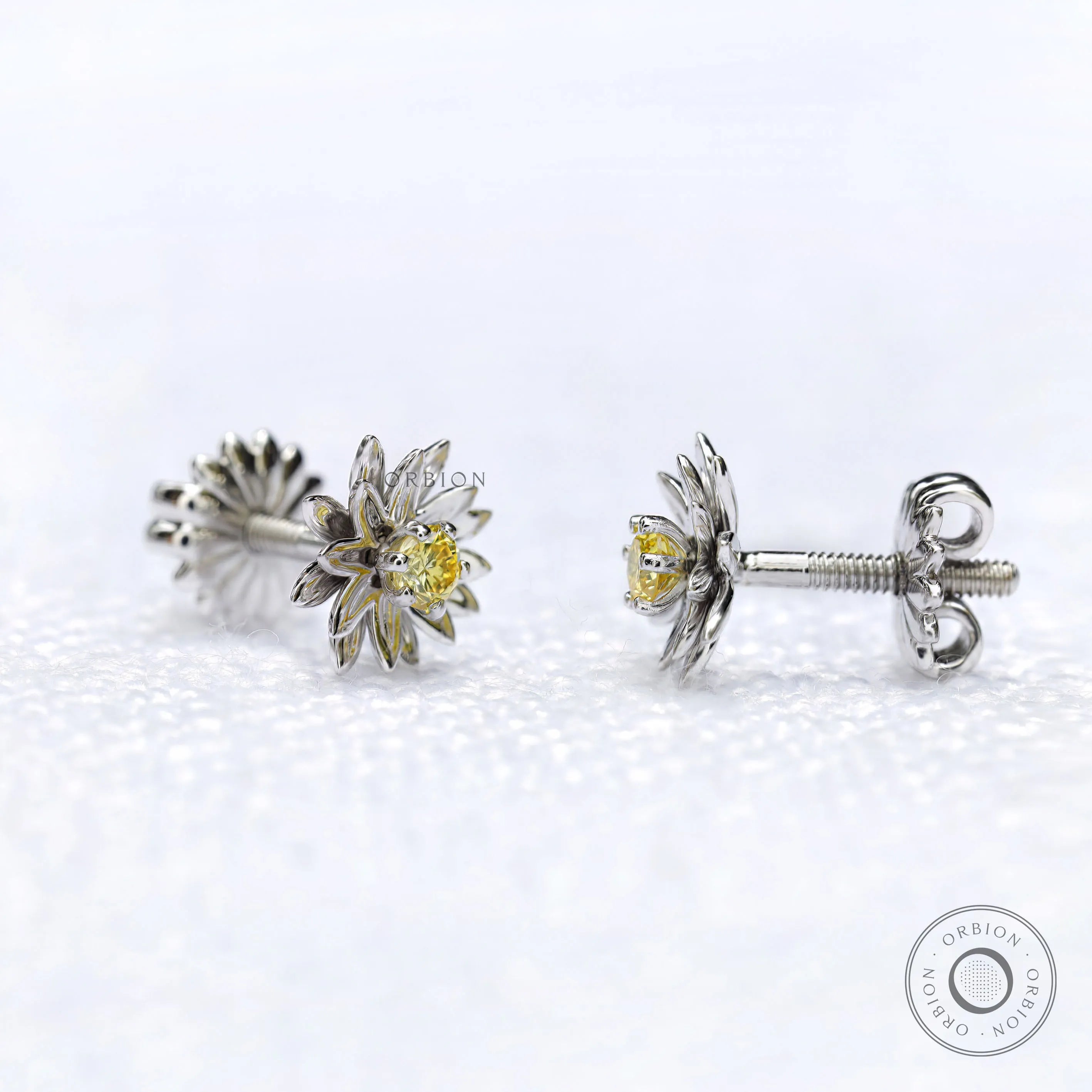 Close-up of lotus flower stud earrings with yellow diamond centerpiece