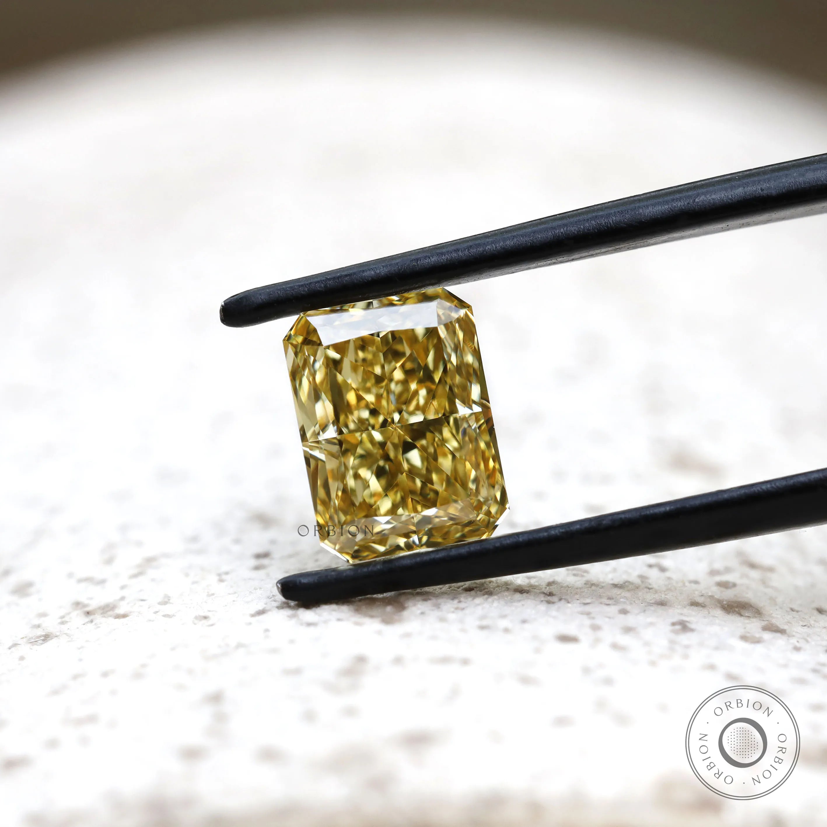 Fancy yellow radiant lab diamond on light textured background